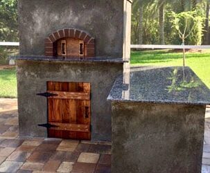 An outdoor kitchen with a custom wood-fired pizza oven built and installed by Forno Nardona in Tampa, FL.