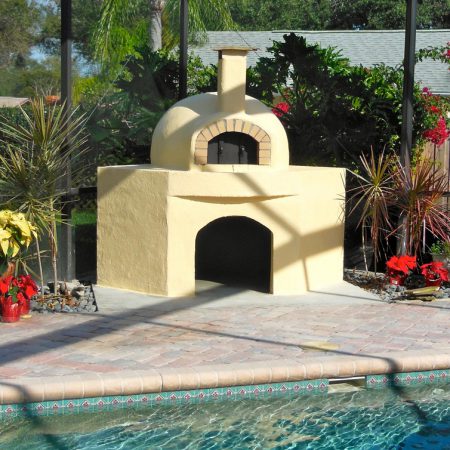 A Forno Nardona crafted wood-fired pizza oven sits outside beside a pool in Tampa, Florida.