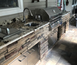 An galley style outdoor kitchen equipped with a Lion BBQ Grill.