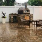 This Forno Nardano copper tiled Rustico outdoor pizza oven creates a welcoming backyard area even in the rain.
