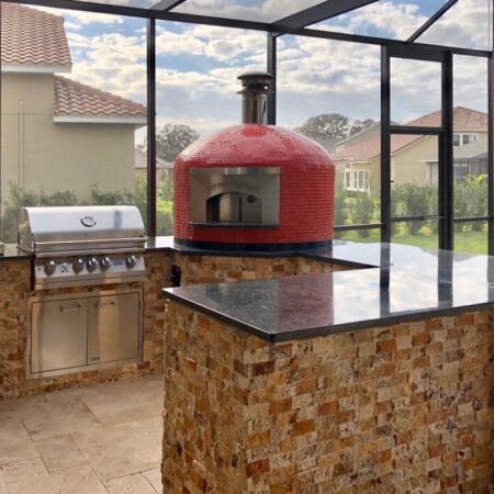 Forno Nardona Napoli oven with personalized face plate and red glass tile sitting on granite in screened outdoor kitchen.