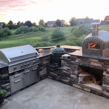 Forno Nardona Rustico oven on corner stoned base with granite countertop with a grand back yard view.