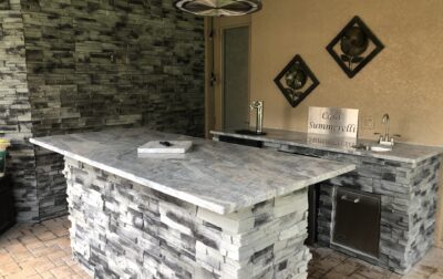 Forno Nardona Tampa built outdoor kitchen/bar made of stone, granite and Lion stainless accessories with island and personalized plate "Casa Summerelli" sign.