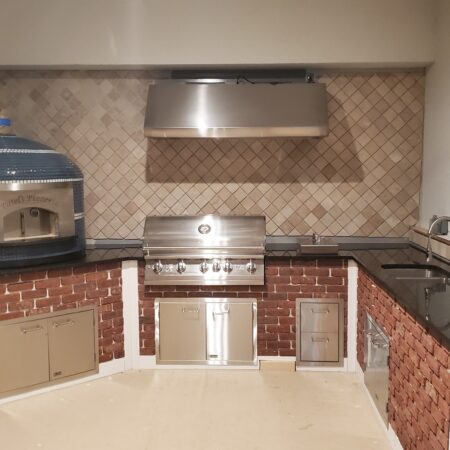 Blue tiled Napoli Oven by Forno Nardona with white striping and black grout positioned on black granite outdoor kitchen.