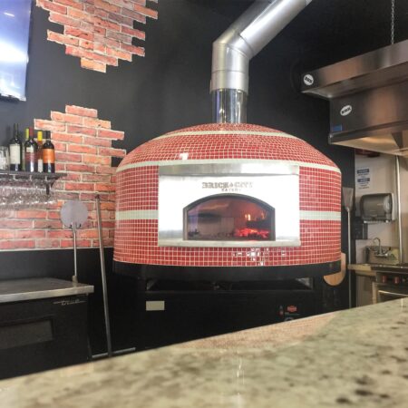 Forno Nardona Napolipizza oven in red and white glass tile with personalized face plate. It says: Brick City Eatery.