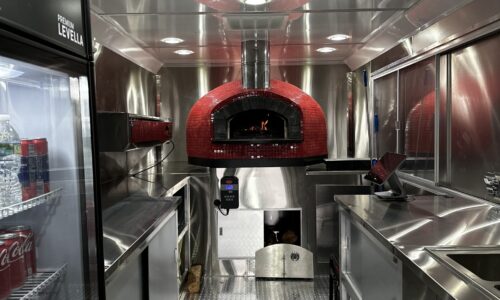 Interior of a pizza truck with a Red Nardona Rustica oven as the central focus.